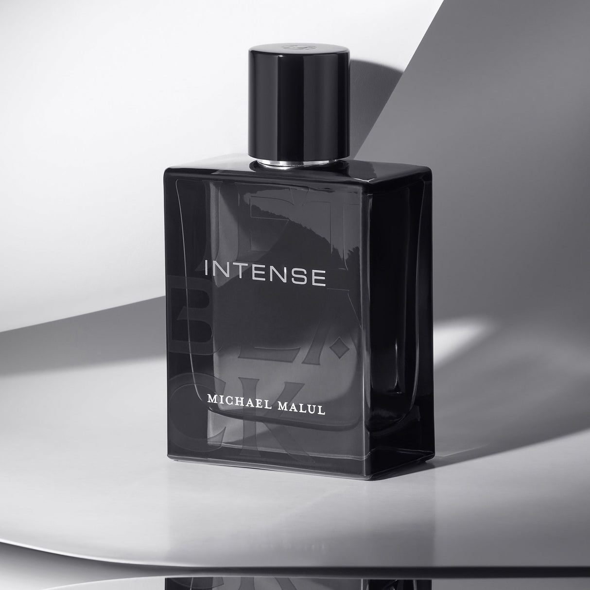 Michael Malul Jet Black Intense Eau de Parfum styled on a dark surface with moody lighting