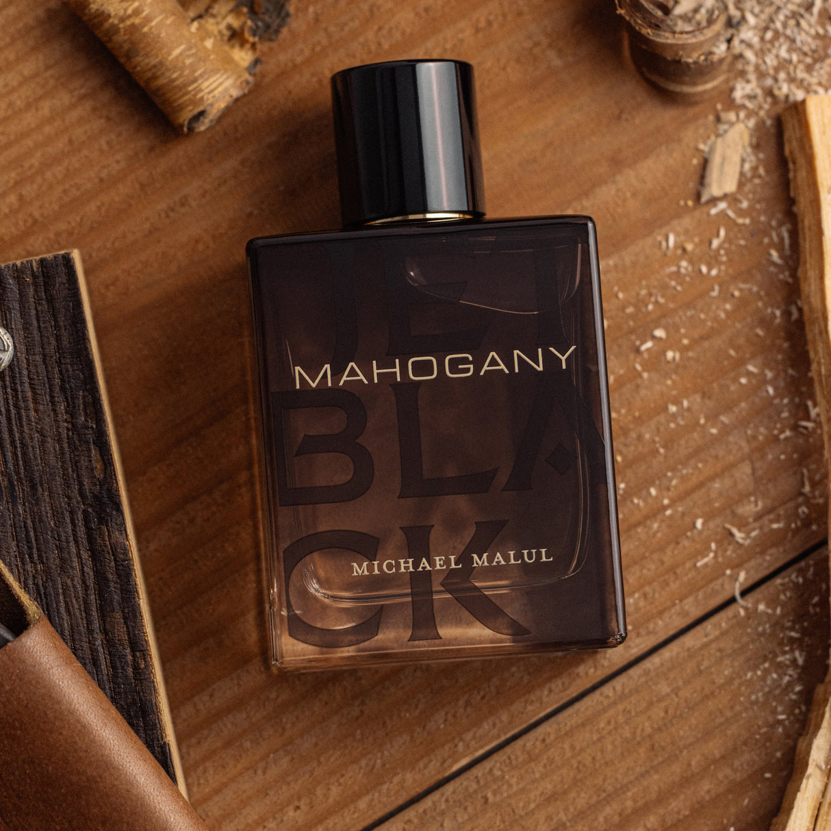 Michael Malul Jet Black Mahogany Eau de Parfum styled on a dark wooden surface