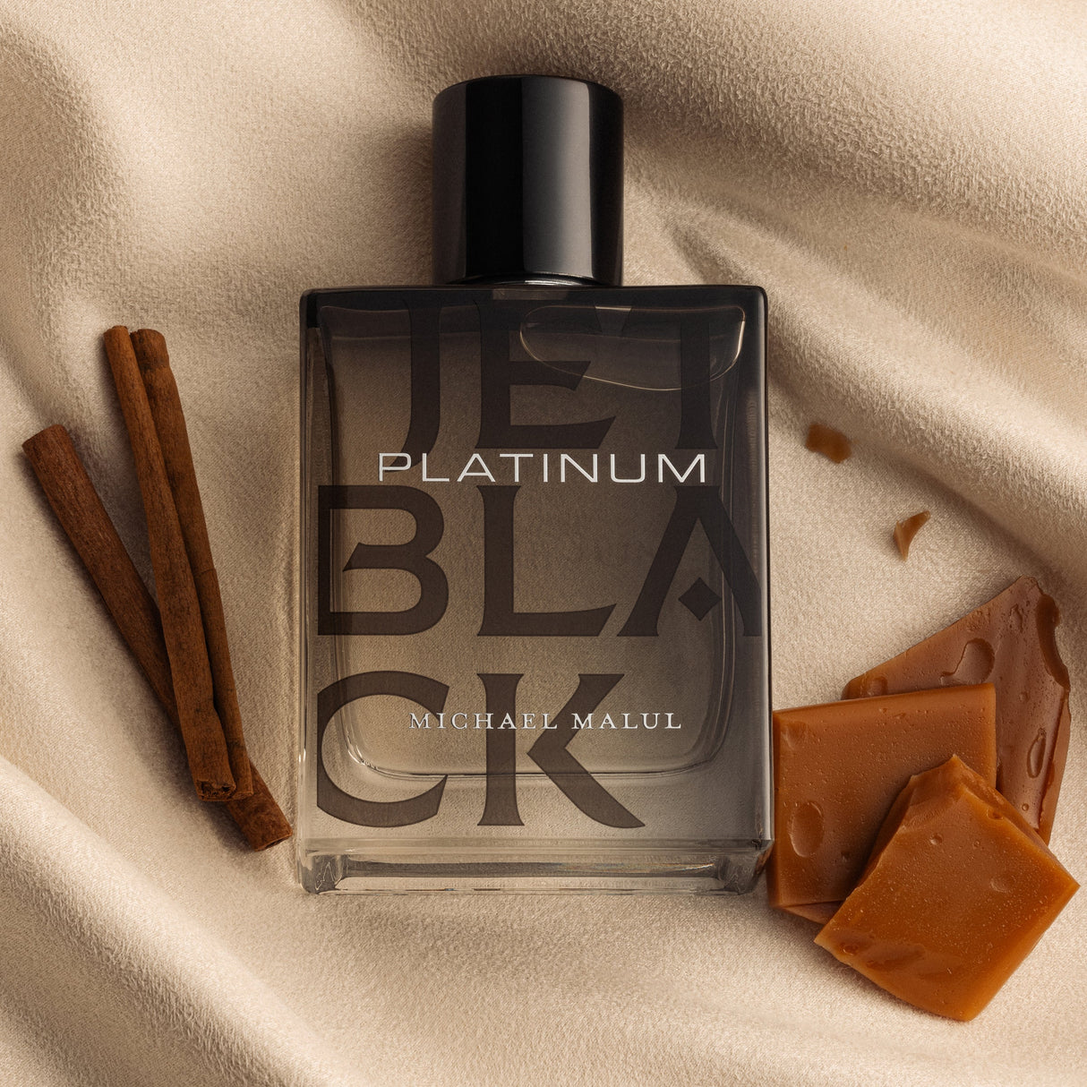 Michael Malul Jet Black Platinum Eau de Parfum styled on a dark surface with warm lighting