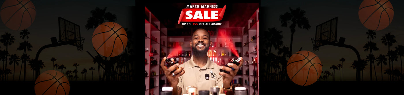 Image of Jean at his shop in Miami Gardens Holding Up to Hawas Bottles and spraying them simultaneously in the air. The lights in the store are set to a dim red.